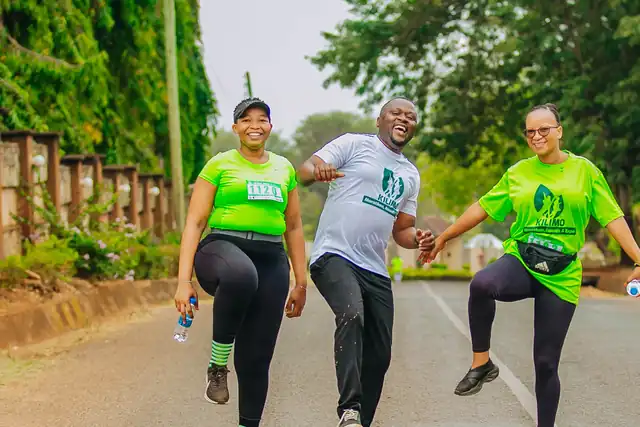Wakimbiaji watatu wakicheza kwa furaha barabarani